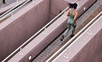 Rear view shot of an unrecognizable woman running outside. Young female focused on her cardio health and fitness while training in the city. Mixed race woman jogging 