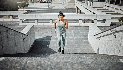 Buy stock photo Athlete, woman and running with headphones on steps for cardio training, listen to music and marathon practice. Active, girl and fitness exercise with endurance, sports workout and race performance