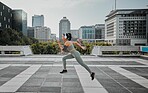 Young mixed race hispanic female wearing headphones listening to music and running outside in the city. Exercise is good for your health and wellbeing