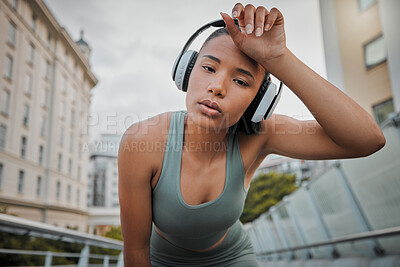 Buy stock photo Woman, portrait and tired athlete in city, wipe sweat and outdoor for streaming music in training. Female person, exhausted runner and wet head in town, morning fatigue and headphones for sound