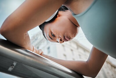 Buy stock photo Woman, thinking and tired athlete in city, low angle and outdoor for streaming music in training. Female person, exhausted runner and contemplating in town, morning fatigue and headphones for sound