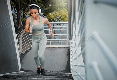 Buy stock photo Woman, stairs and headphones for city fitness, listening and outdoor music for endurance. Female person, sports workout and cardio for marathon training, athlete and streaming sound for motivation