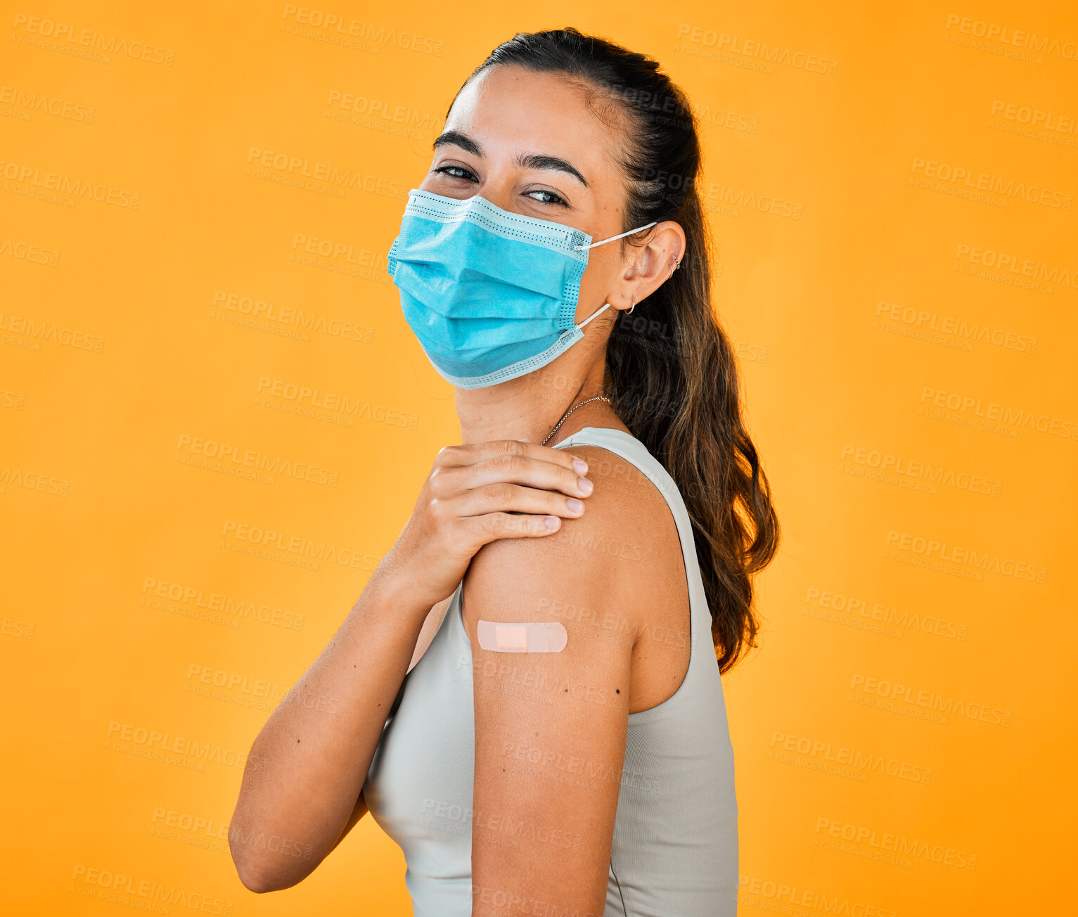 Buy stock photo Woman, covid and bandage with face mask for vaccination, safety and immunization for health. Portrait, model and compliance for pandemic, prevention and protection on yellow background in studio 