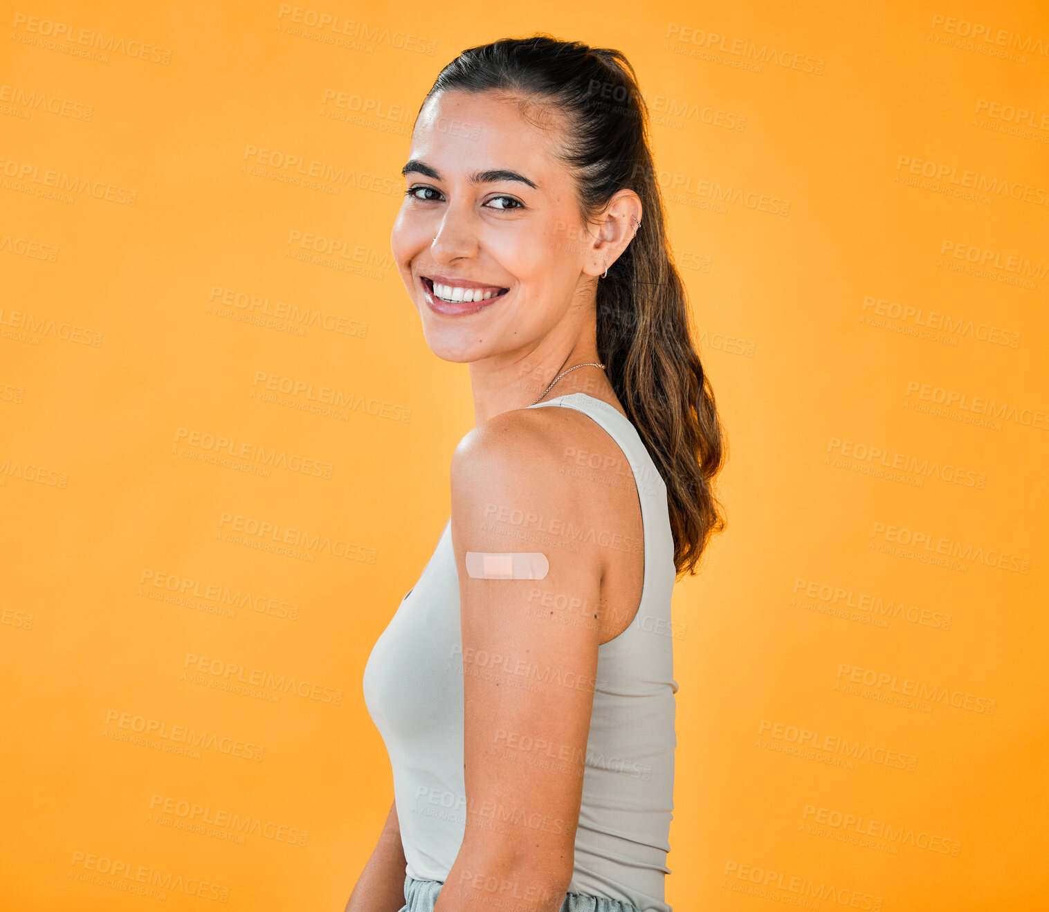 Buy stock photo Portrait, woman and plaster for vaccination in studio with healthcare choice, medical insurance and mpox safety. Smile, girl and bandage with injection for medicine, stop virus and yellow background