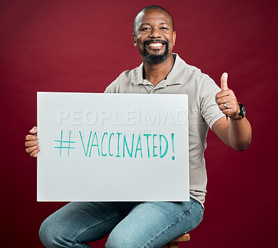 Buy stock photo Poster, thumbs up and vaccine with portrait of black man in studio on red background for healthcare or medical. Hashtag, social media or smile of person with sign for covid awareness or prevention