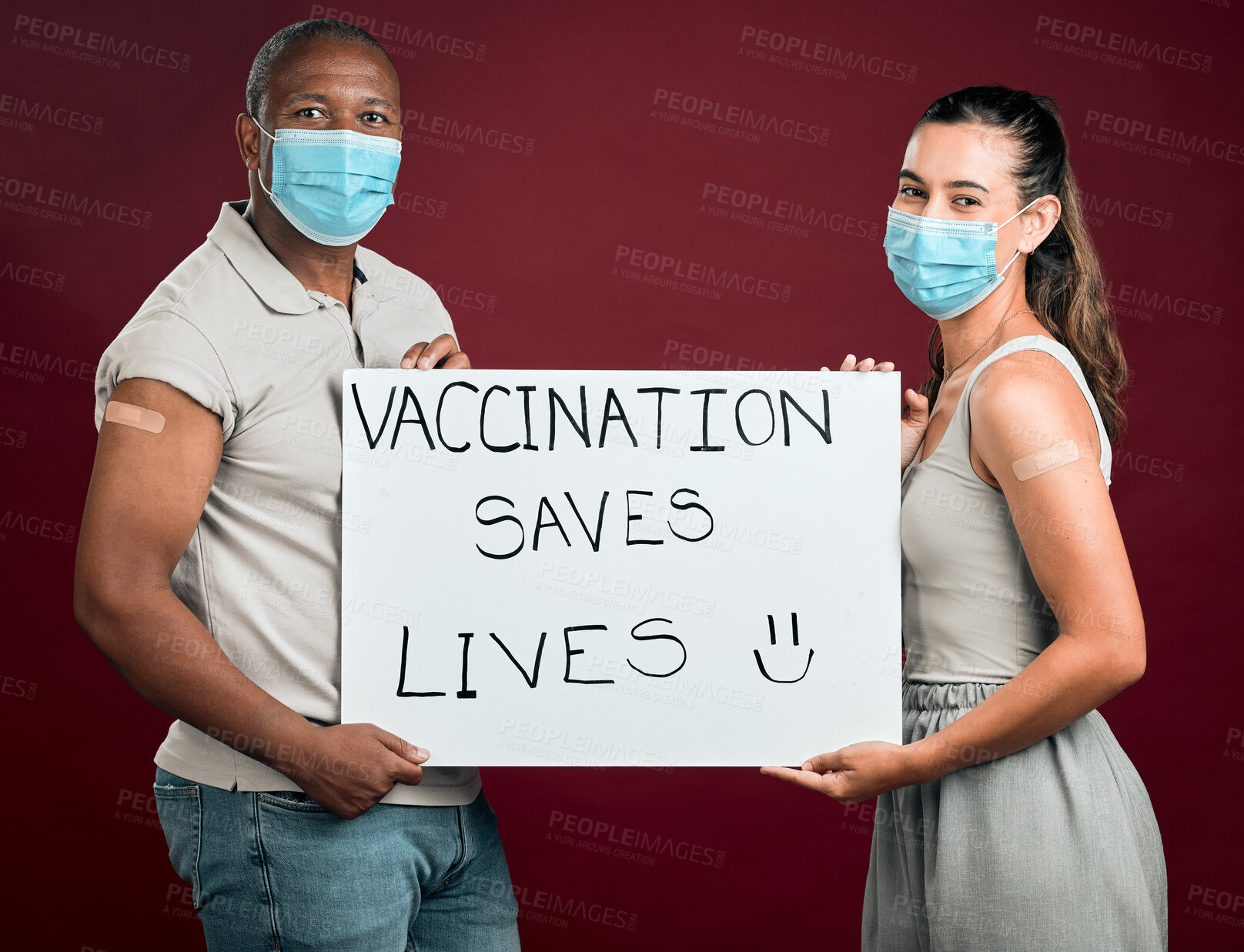 Buy stock photo Covid, mask and poster with portrait of people in studio on red background for healthcare or medical. Control, pandemic and vaccination saves lives sign with friends together for support or wellness