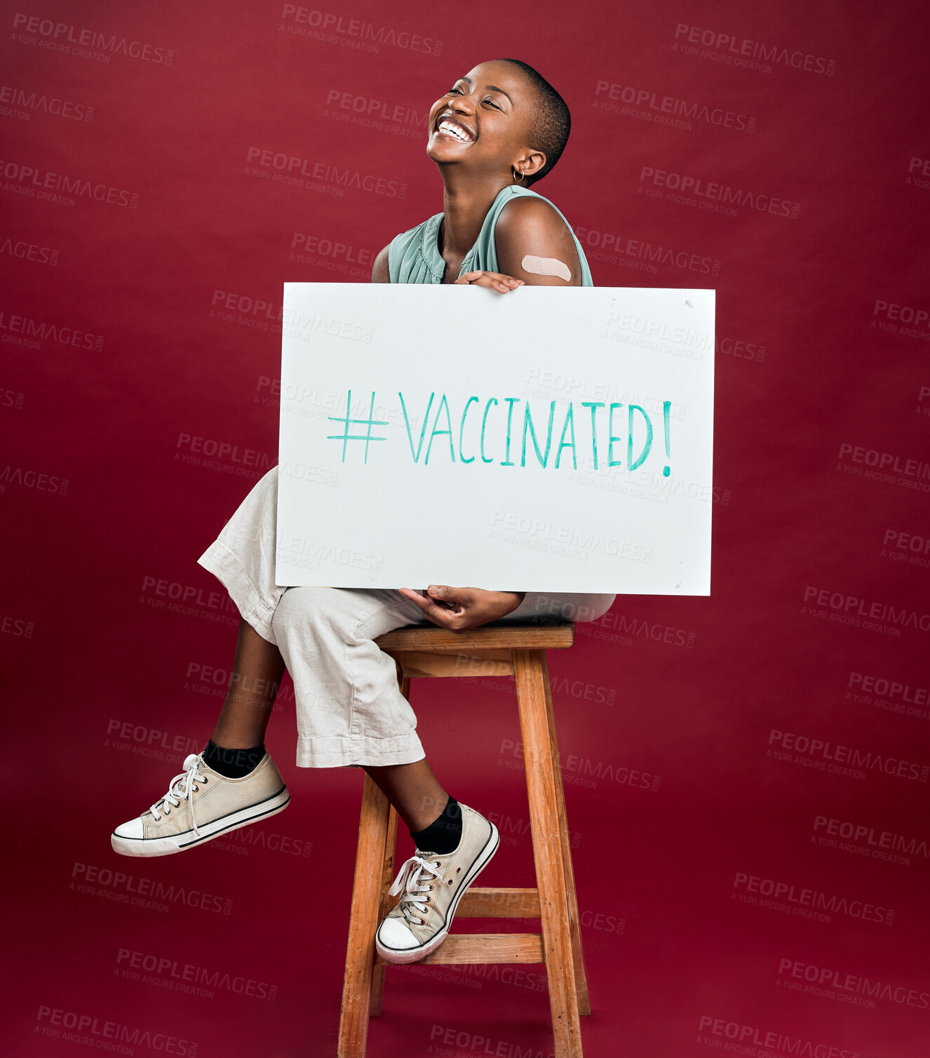 Buy stock photo Poster, smile and vaccine with black woman in studio isolated on red background for healthcare or medical. Chair, hashtag and plaster with patient holding sign for covid awareness or prevention