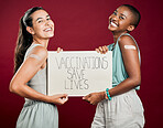 Covid vaccinated African american and mixed race women showing and holding poster. Two people isolated on red studio background with copyspace. Showing plaster on arm and promoting corona vaccine