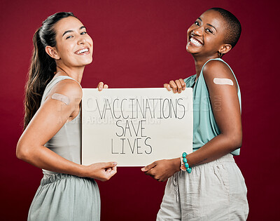 Buy stock photo Covid, poster and plaster with portrait of people in studio on red background for healthcare or medical. Pandemic, smile and vaccination saves lives sign with woman friends together for wellness