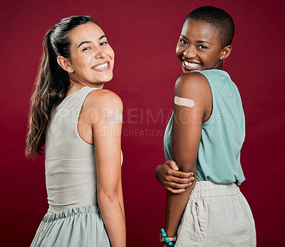 Buy stock photo Women, friends and vaccine with plaster in studio background for protection. People, happy and satisfied or smile for healthcare on portrait with bandage on arm for virus immunity and prevention