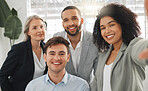 Portrait of a group of cheerful diverse businesspeople taking a selfie together at work. Happy mixed race businesswoman taking a photo with her joyful colleagues