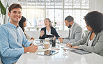 Portrait of a young caucasian businessman writing in a notebook while sitting in a meeting at work. Group of businesspeople having a meeting together at a table. Business professionals talking and planning in an office