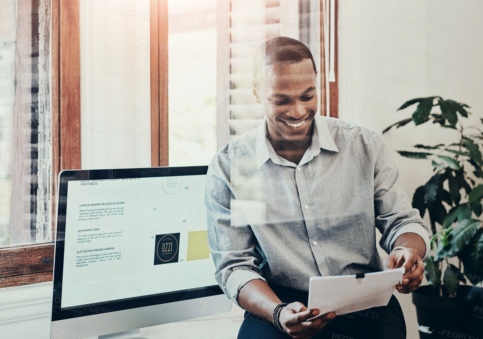 Buy stock photo Computer, reading and happy man in office with paperwork, relax and research for online design. Smile, creative and businessman at desk with documents, ideas and report feedback at digital agency