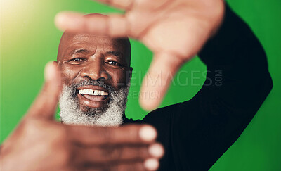 Buy stock photo Senior black man, hand frame and studio portrait with smile, excited and emoji by green background. Elderly person, happy and sign for photography, perspective and emoji with confidence in Nigeria