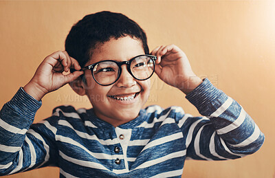 Buy stock photo Eye care, child and happy on studio background with glasses, thinking and testing new lens. Young boy, excited and specs on face for vision, optometry and wellness with medical insurance for eyesight