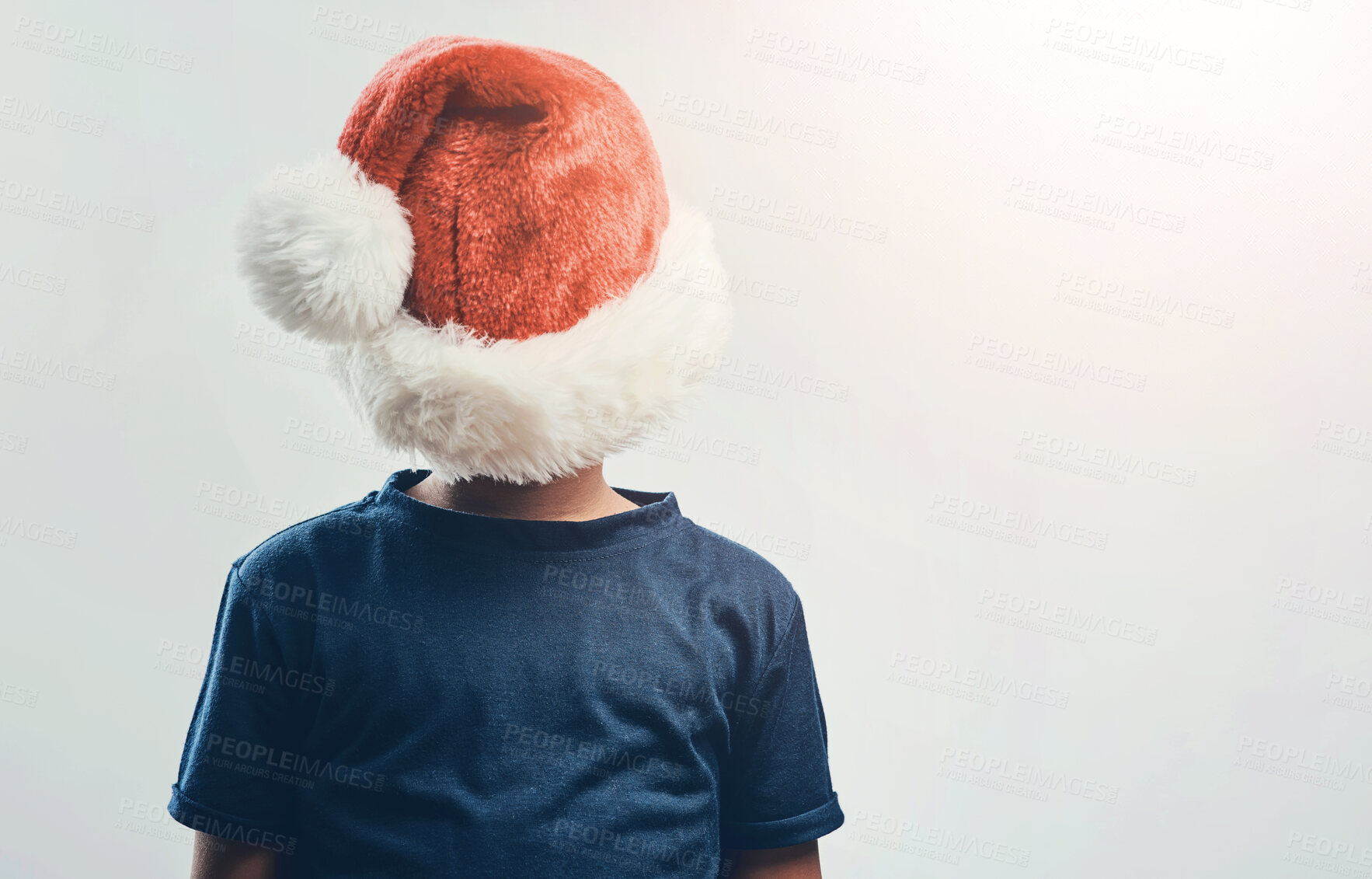 Buy stock photo Christmas, hat and back of child in studio waiting for holiday, vacation and festive season. Mockup space, Santa decoration and isolated kid for tradition, celebration and event on white background