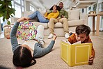 Home, parents and kids on carpet, relax and playing games for weekend break, comfort and calm. Reading book, family and mother with father, childhood development and toys with fun, joy and happiness