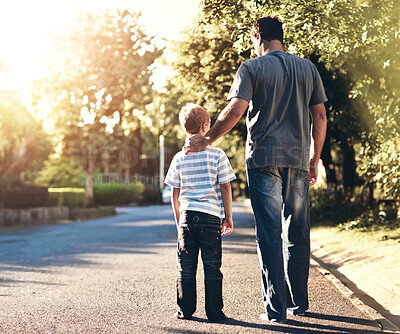 Buy stock photo Dad, child and walking on neighborhood street, together and bonding with son on weekend. Father, boy and back of people on road for care in conversation, love and family communication for security