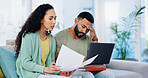 Frustrated couple, headache and documents with laptop for expenses, bills or financial problems on sofa at home. Young, man and woman with stress, paperwork or invoices for debt or mortgage at house