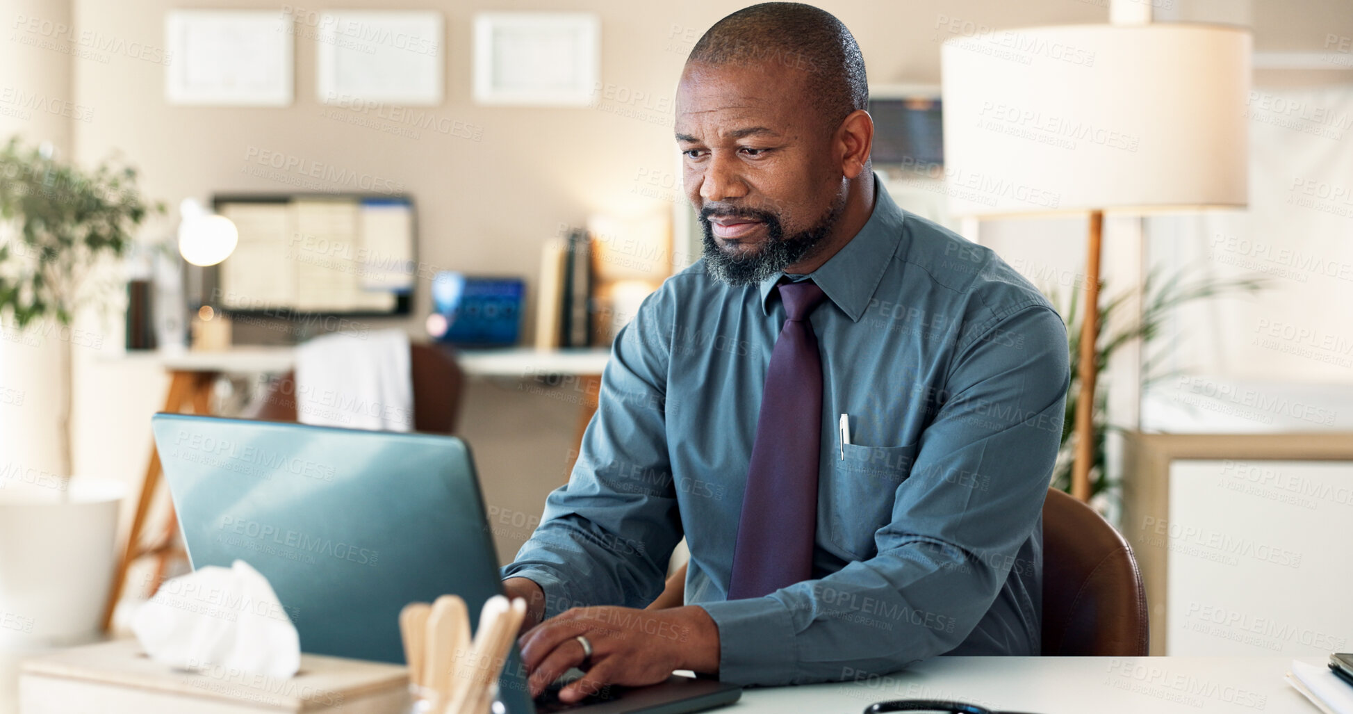 Buy stock photo Black man, doctor and typing with laptop for communication, email or telehealth at hospital. African, male person or medical employee with computer for pharmaceutical research or chat at clinic desk