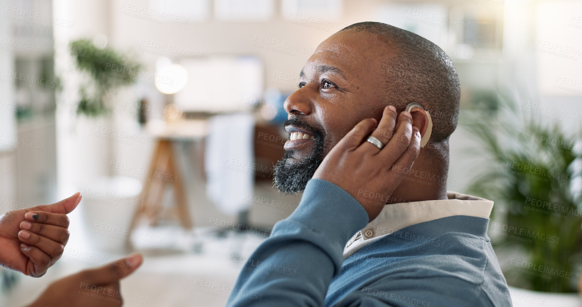 Buy stock photo Black man, smile and hearing aid in hospital for healthcare, help and doctor with thumbs up for approval. Mature person with disability, cochlea implant and ENT specialist in clinic for consultation