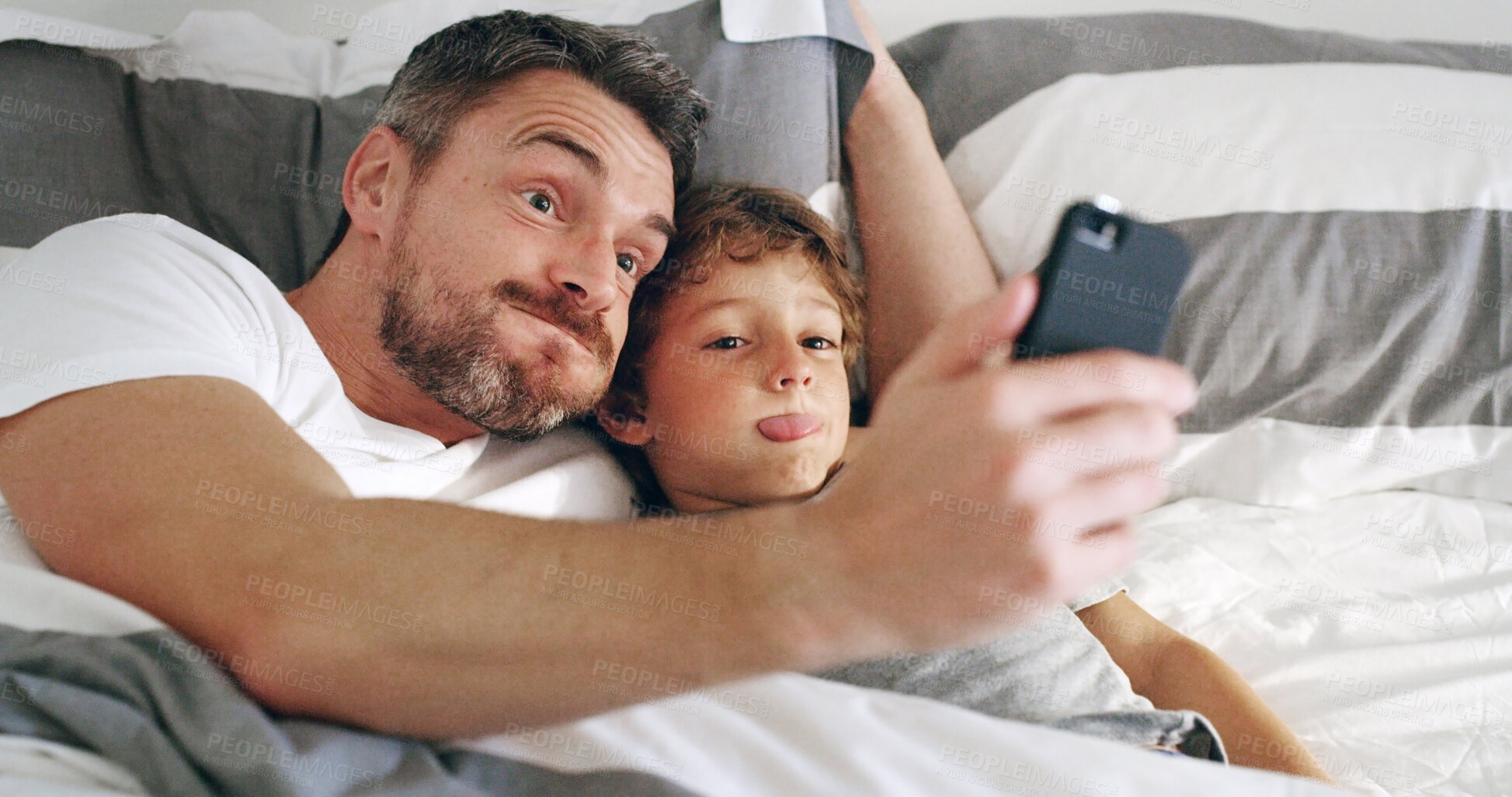 Buy stock photo Bed, father and funny face with boy on selfie for memories, social media and profile picture at home. Apartment, people and happy parent with kid as family for love, support and bonding in bedroom