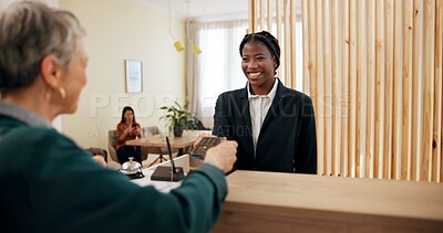 Buy stock photo Concierge, women and hotel reception with payment, credit card and customer service. Spa lobby, smile and transaction with business support, guest help and booking agent at resort counter with tech