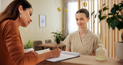 Buy stock photo Women, customer and receptionist with signature at spa for luxury service, booking and reservation. People, employee and guest with smile at front desk for registration, filling form and agreement