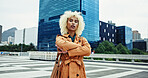 Street, urban fashion and woman with arms crossed or confidence in trendy coat in New York. Outdoor, serious or creative female designer walking in city for travel, commute or sightseeing on holiday