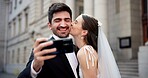 Couple, selfie and kiss with wedding in city, love and happy for commitment, memory and post on web. People, man and woman with marriage, event and celebration with smile on social media in Greece