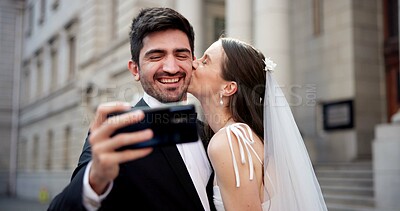 Buy stock photo Couple, selfie and kiss with wedding in city, love and happy for commitment, memory and post on web. People, man and woman with marriage, event and celebration with smile on social media in Greece