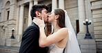 Couple, embrace and kiss on wedding outdoor with promise, celebration and marriage commitment. People, trust and love with affection of partnership, relationship loyalty and romance ceremony at court