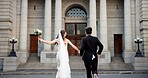 City, walking and back of couple for wedding at town hall for marriage certificate, ceremony and legal matrimony. Holding hands, love and man and woman at court for commitment, promise or partnership