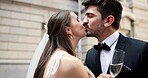 Wedding, kiss and couple in city with champagne at ceremony, celebration and commitment. Romance, alcohol toast and man and woman in town for promise, partnership and marriage certificate at court