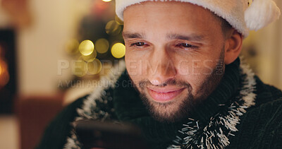 Buy stock photo Christmas, happy and man with phone in home for holiday, vacation and festive season. Relax, night and person on smartphone for reading xmas message on social media, internet chat and mobile app