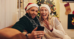 Christmas, wave and couple on video call in home for communication, contact and online chat. Love, happy and man and woman on smartphone talking for festive tradition, holiday wish and vacation