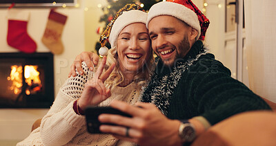 Buy stock photo Christmas, peace sign and selfie of couple in home take photo for profile picture, social media post and memory. Love, emoji and happy man and woman on sofa for festive tradition, holiday or vacation