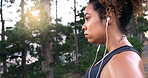 Woman, runner and earphones with sweat, outdoor or perspective with music, fatigue or fitness training in woods. Girl, reflection and streaming for exercise, workout and tired in forest in Costa Rica