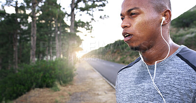 Buy stock photo Man, runner and earphones in road, outdoor and perspective with music, break and fitness training in summer. African person, reflection and streaming for exercise, workout or sound by forest in Kenya