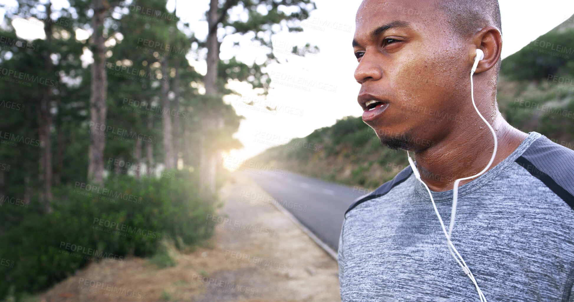 Buy stock photo Man, runner and earphones in road, outdoor and perspective with music, break and fitness training in summer. African person, reflection and streaming for exercise, workout or sound by forest in Kenya