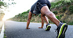 Man, runner and stretching for exercise on mountain road with warm up, start and low angle with legs. Person, fitness and training with wellness, health and outdoor for performance in Nigeria