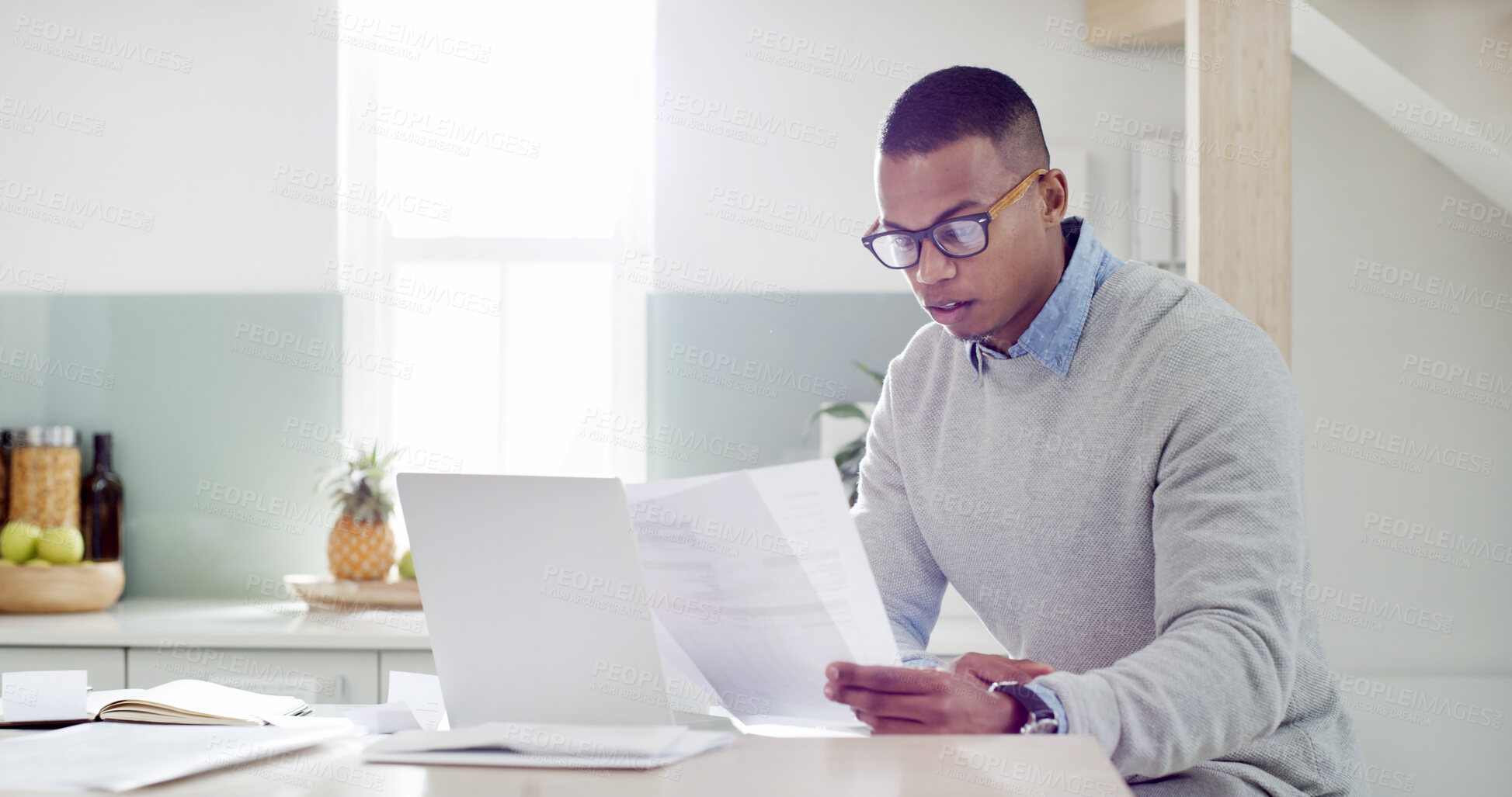 Buy stock photo Man, research and paperwork in kitchen for mortgage review, insurance documents and bills in home. Guy, computer and check documents with asset management, tax registration and budget spreadsheet