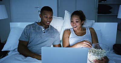 Buy stock photo Shocked, couple and watching on laptop at night for horror movie, eating popcorn and bonding together. People, relaxing and snack with online streaming, scary film and entertainment services at house