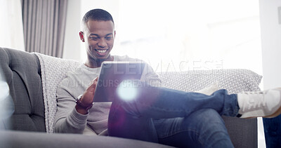 Buy stock photo Happy man, tablet and relax on sofa with social media, streaming service and funny video in home. Male person, smile and tech in living room for comedy show, viral meme or connectivity with ebook app