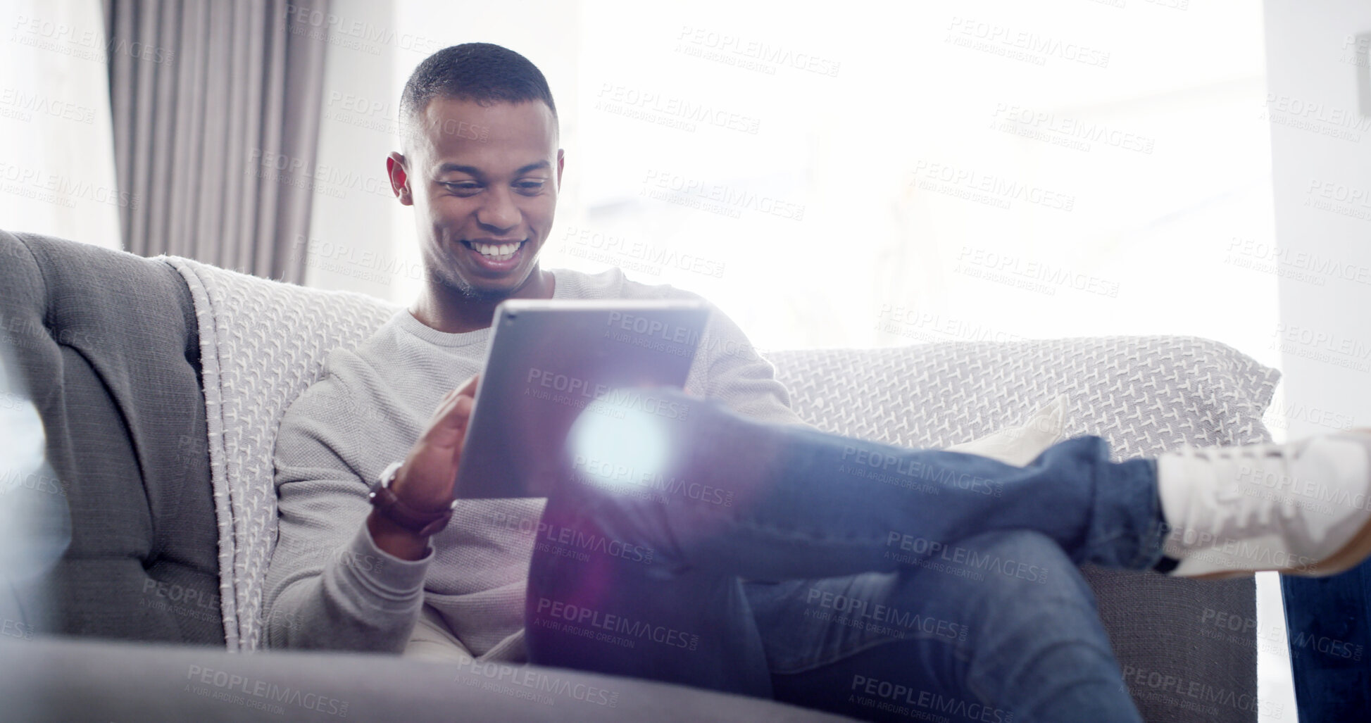 Buy stock photo Happy man, tablet and relax on sofa with social media, streaming service and funny video in home. Male person, smile and tech in living room for comedy show, viral meme or connectivity with ebook app