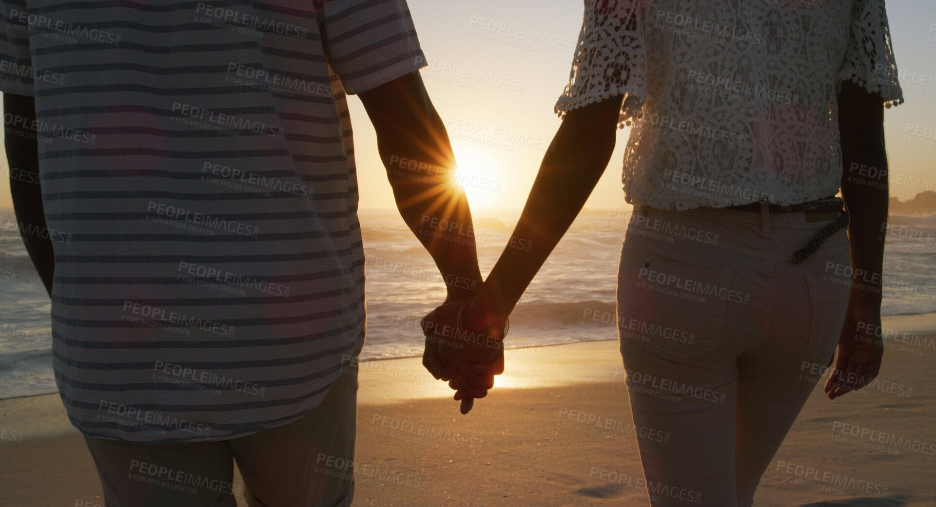 Buy stock photo Couple, sunset and holding hands at beach for travel, holiday and love together with back, care or trust. Man, woman and bonding by ocean for vacation, romance or connection with relationship on date