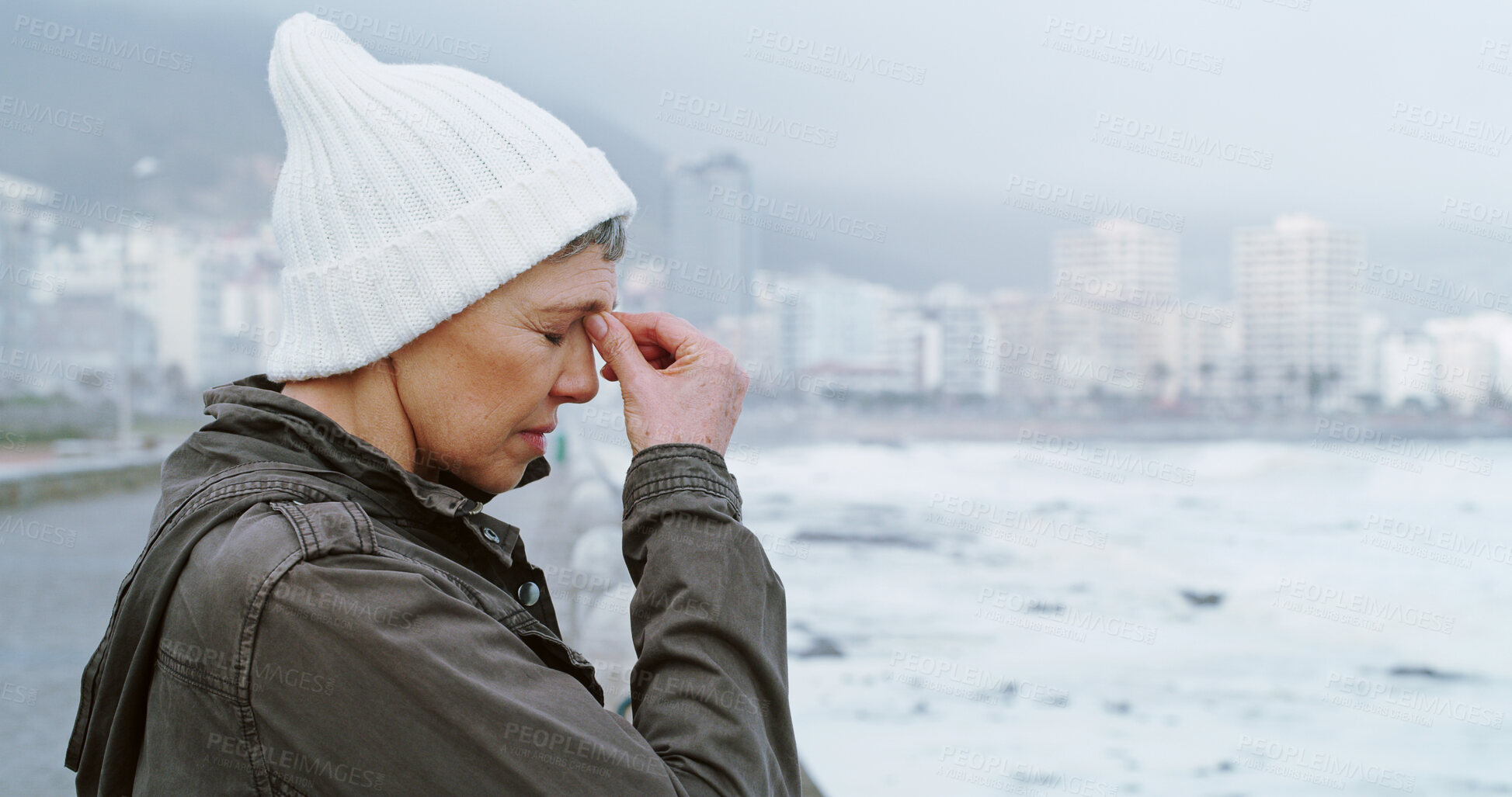 Buy stock photo Senior woman, thinking and depression by ocean promenade with headache, stress and reflection. Person, sad and insight for mistake, fog and decision with anxiety by sea, waves and outdoor in Italy