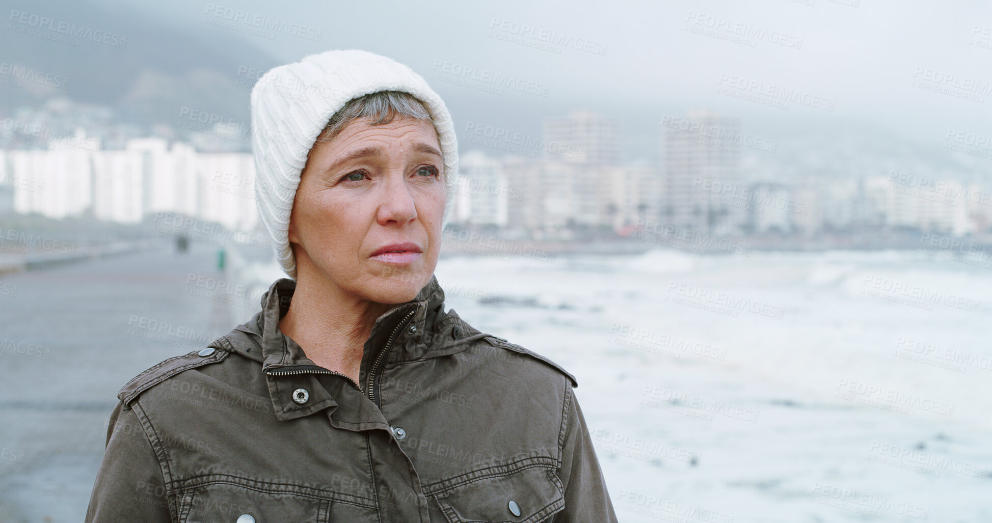 Buy stock photo Sad, beach and mature woman with thinking, grief and loss outdoor with depression and mental health. Lonely, sea and winter vacation with travel, memory and bad news by ocean to remember the past