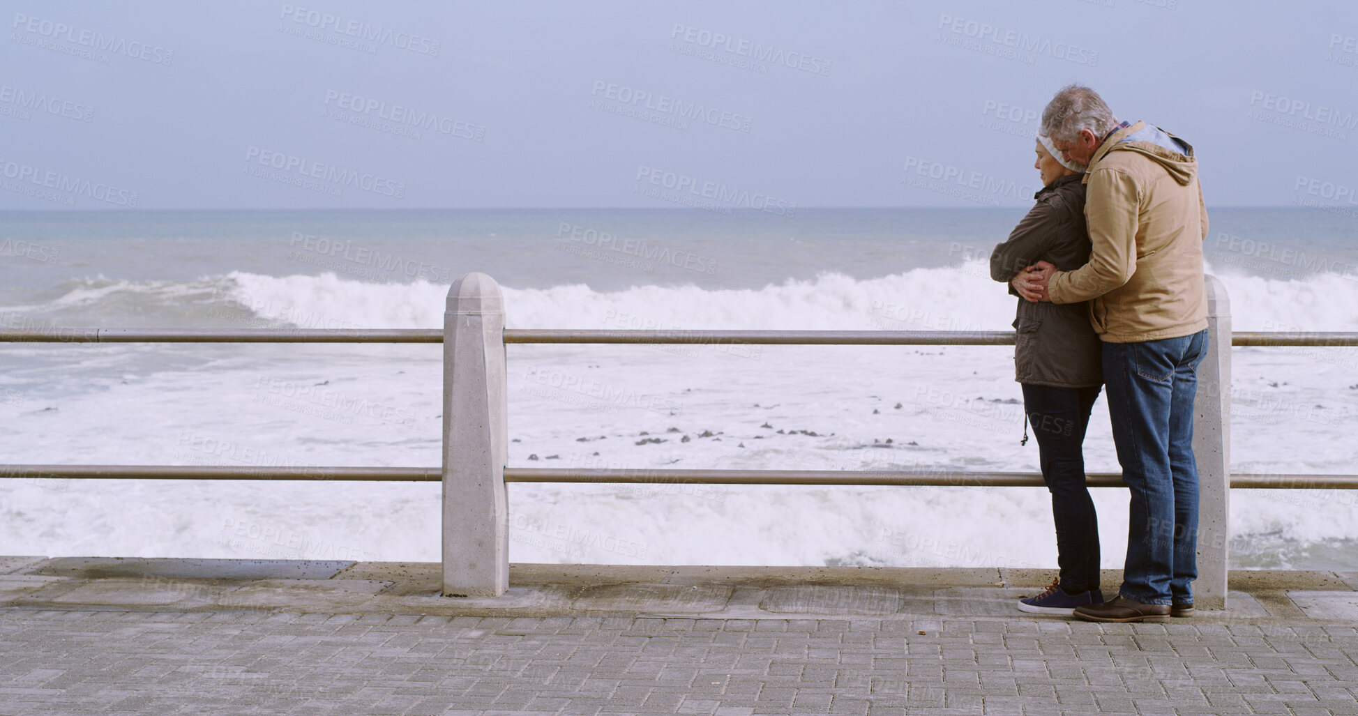 Buy stock photo Mature couple, hug and bonding together by ocean, water and beach for love, partnership and support. Woman, man and embrace in relationship, marriage or care as outdoor, vacation or holiday in winter