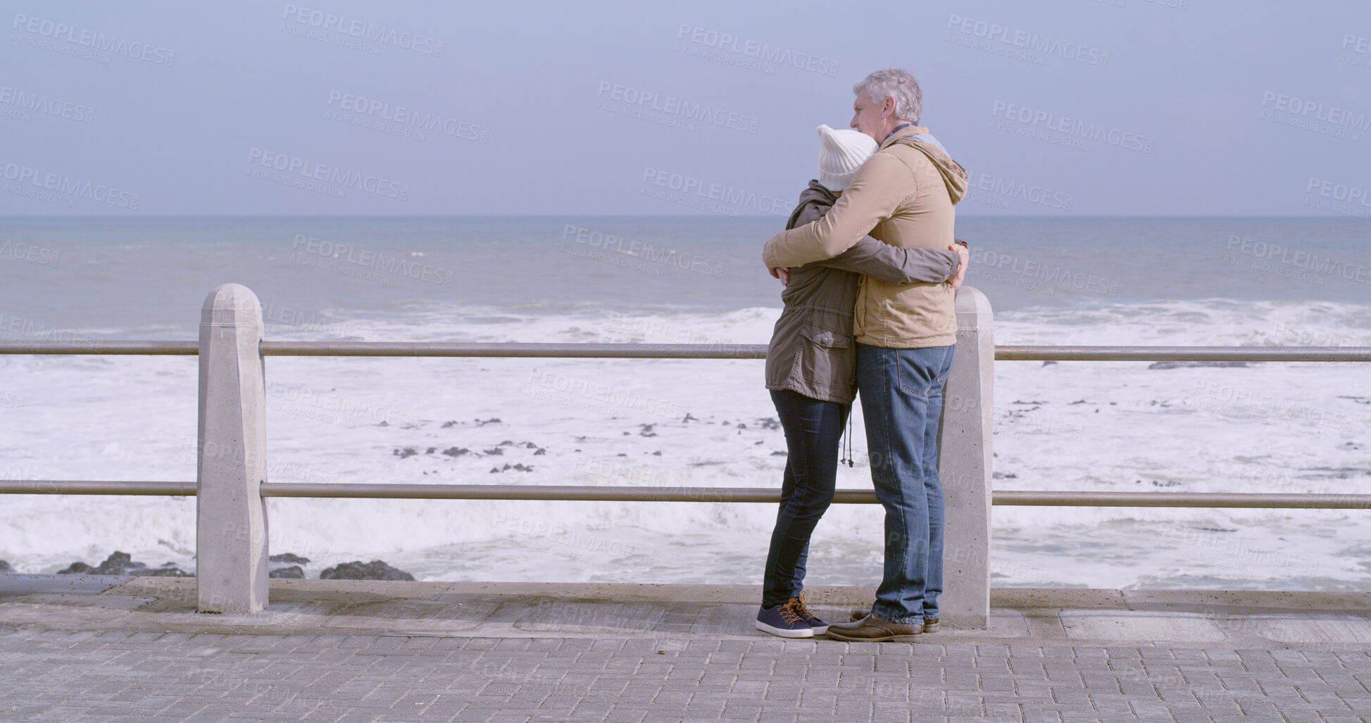 Buy stock photo Mature couple, hug and care by ocean, water and beach for love, partnership and bonding together. Woman, man and embrace in relationship, support or marriage with outdoor, vacation or holiday in city